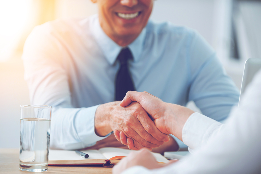 Dealership Finance employee shaking hands with customer